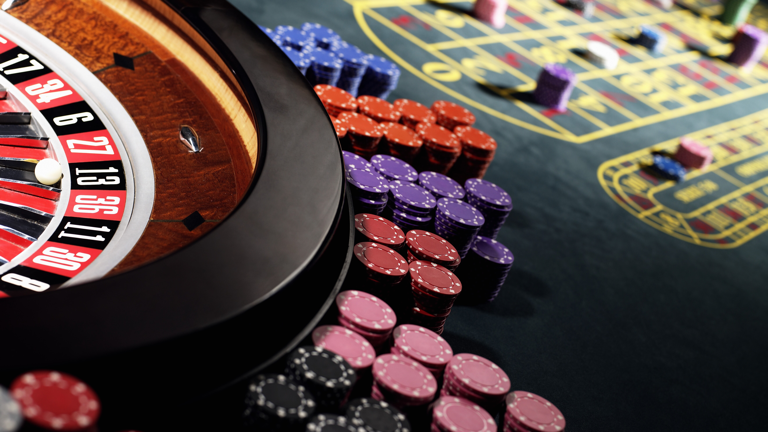 Roulette wheel beside casino playing chips