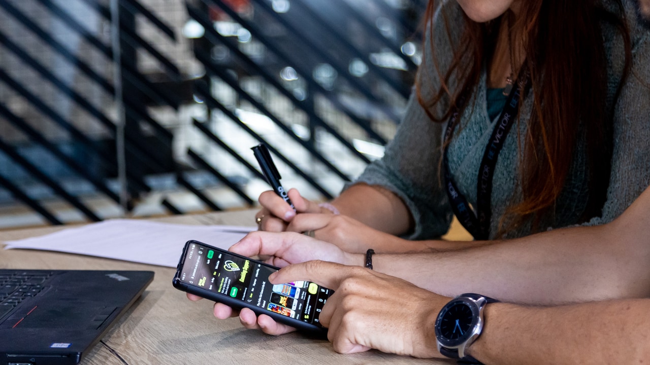 BVGroup colleagues reviewing a mobile casino interface beside a laptop